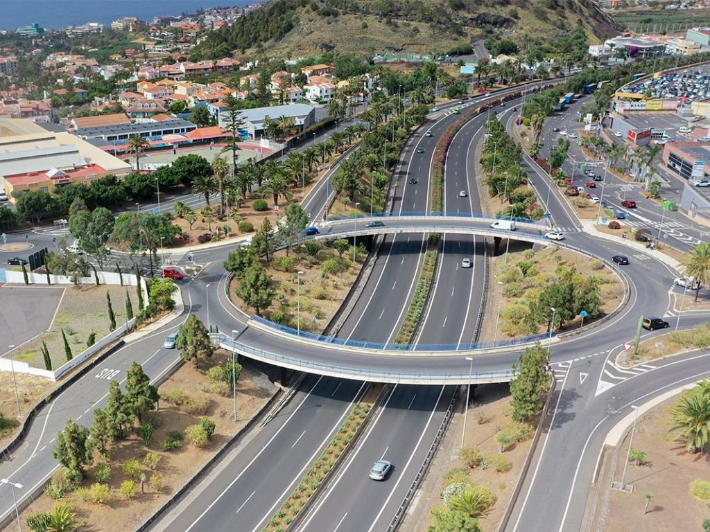 Vista de una autopista con una rotonda en altura y las zonas verdes aledañas